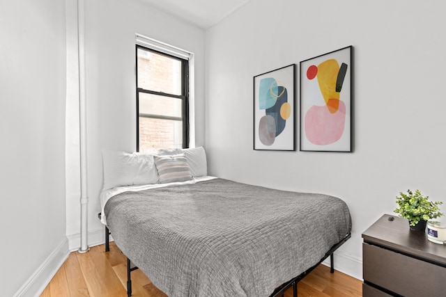 bedroom with baseboards and wood finished floors