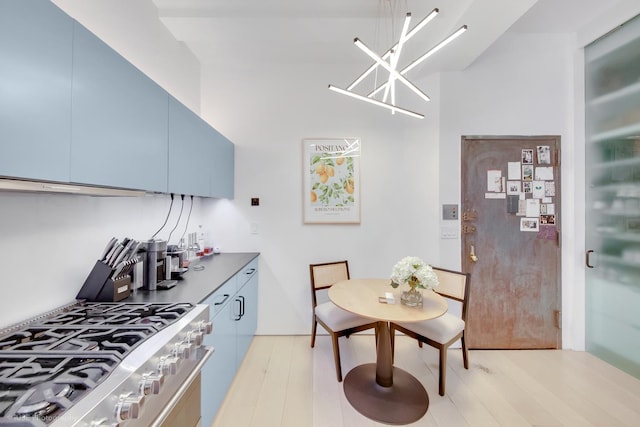 425 Park Ave S Unit 4D, New York City, NY 10016 - kitchen with blue cabinetry, gas stove, light wood-style floors, and a high ceiling