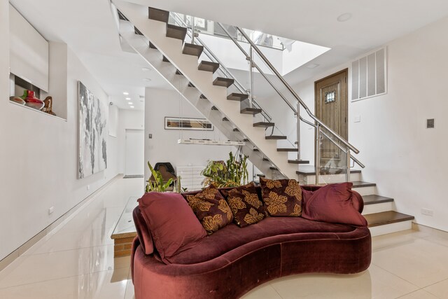 333 W 262nd St, New York City, NY 10471 - tiled living room with visible vents, baseboards, stairway, and a skylight