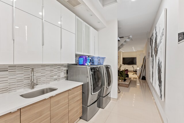 333 W 262nd St, New York City, NY 10471 - washroom featuring light tile patterned floors, washing machine and dryer, visible vents, cabinet space, and a sink