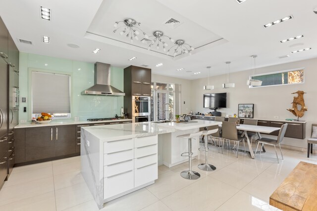 333 W 262nd St, New York City, NY 10471 - kitchen with modern cabinets, wall chimney range hood, a breakfast bar, a sink, and a spacious island
