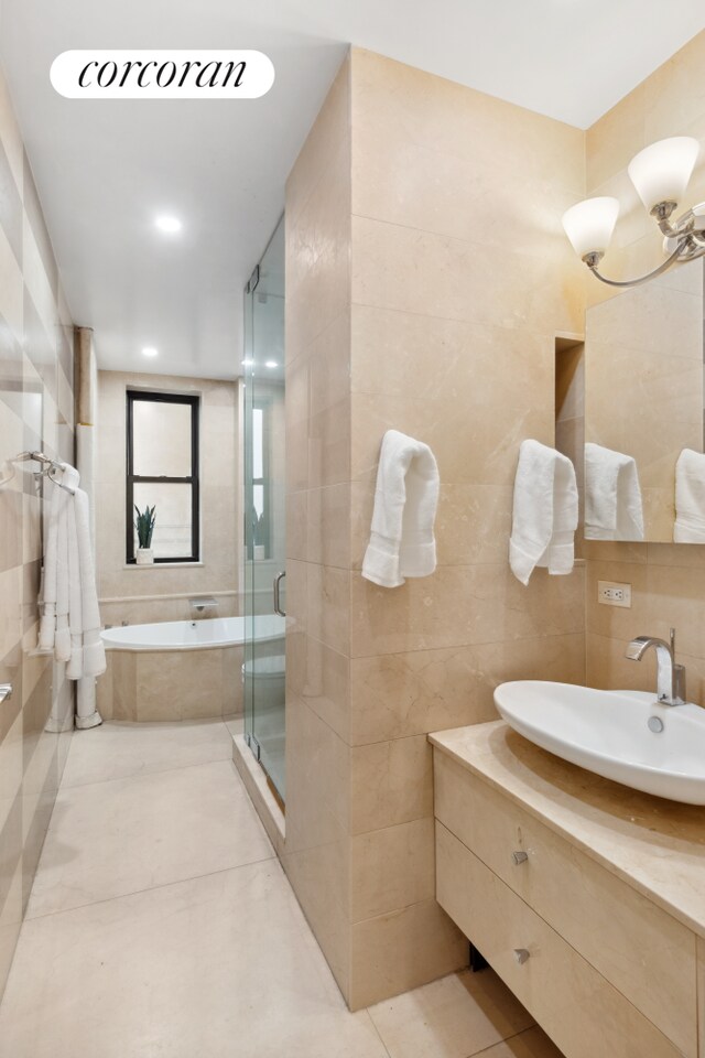215 W 91st St Unit 111, New York City, NY 10025 - full bath featuring tile walls, a bath, vanity, a shower stall, and tile patterned flooring