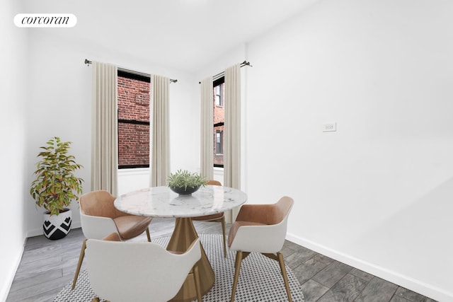 dining area with baseboards and wood finished floors