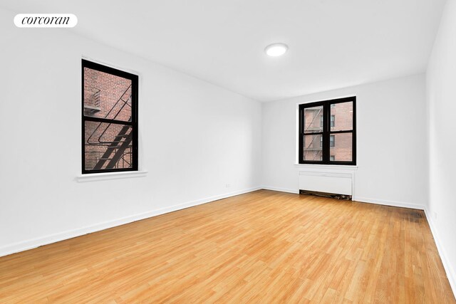 unfurnished room with wood finished floors and baseboards