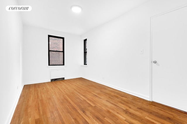 spare room featuring light wood finished floors and baseboards