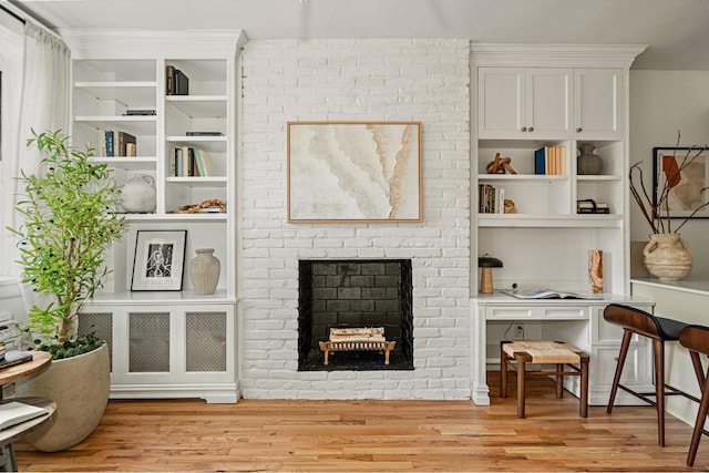 living room with light wood-style flooring and a brick fireplace
