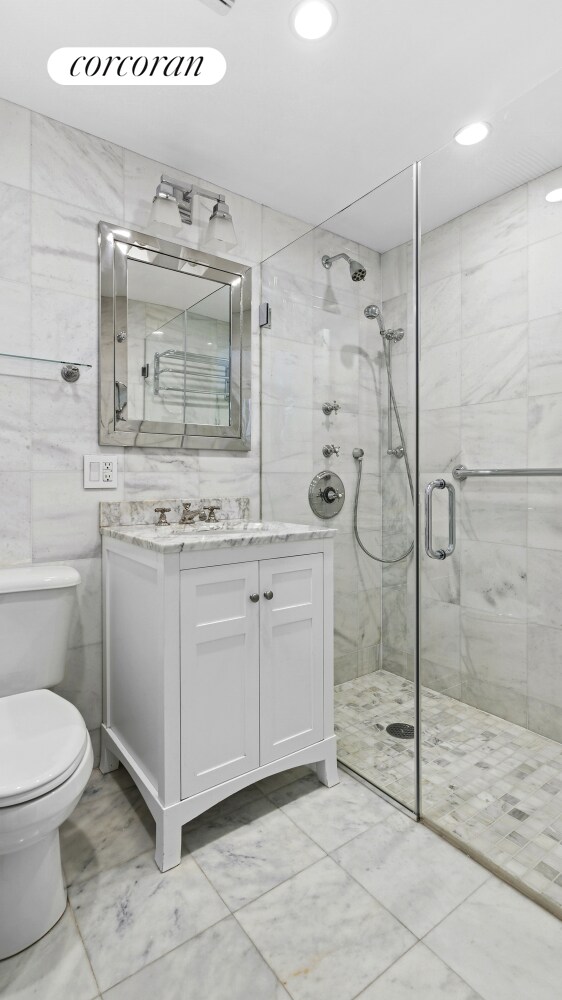 111 E 56th St Unit 1601, New York City, NY 10022 - full bath featuring tile walls, toilet, a shower stall, and vanity