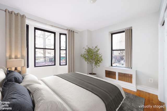 bedroom with baseboards and wood finished floors