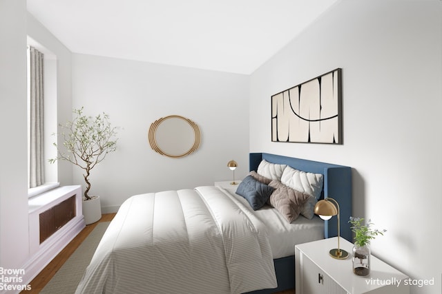 bedroom with baseboards and wood finished floors