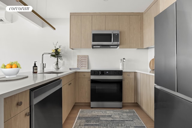 kitchen with light brown cabinets, light countertops, a sink, and appliances with stainless steel finishes