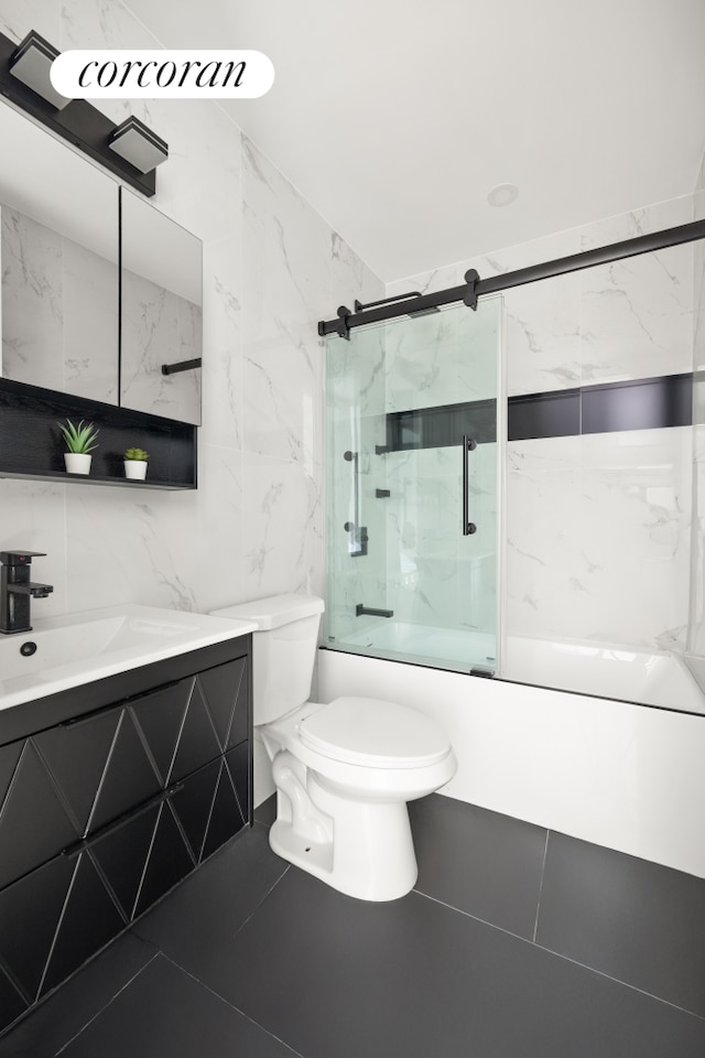 bathroom featuring vanity, tile walls, toilet, tile patterned flooring, and shower / bath combination with glass door