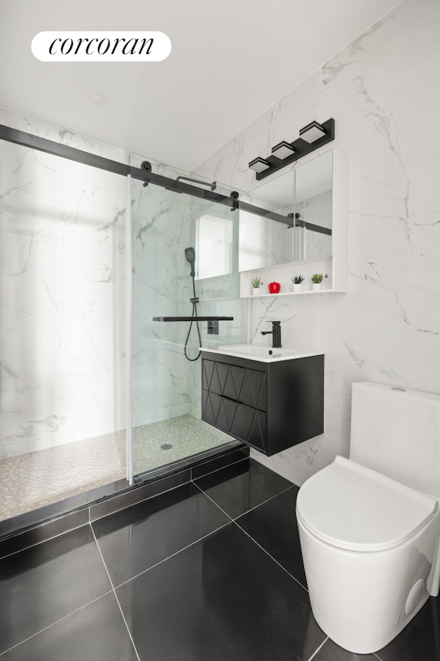 full bathroom with tile walls, toilet, vanity, and a marble finish shower