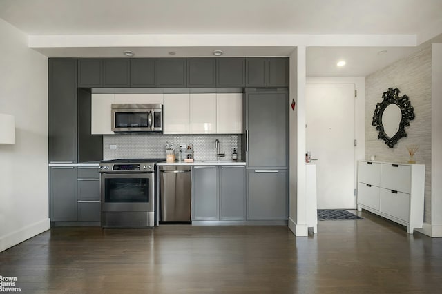 432 W 52nd St Unit 7H, New York City, NY 10019 - kitchen with appliances with stainless steel finishes, dark wood-style flooring, gray cabinets, and recessed lighting
