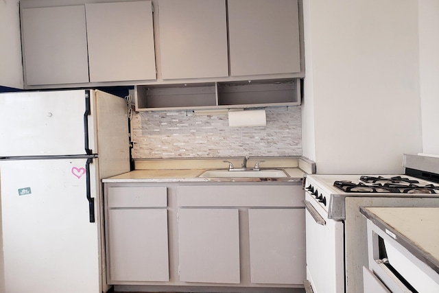 kitchen featuring tasteful backsplash, a sink, white appliances, and light countertops