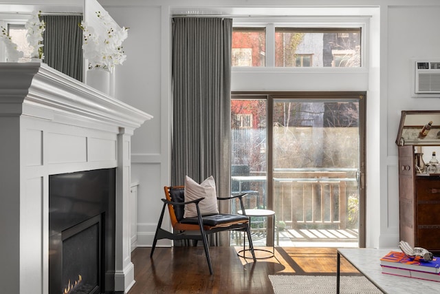 428 W 23rd St Unit 1A, New York City, NY 10011 - sitting room featuring a lit fireplace, a wall mounted air conditioner, and dark wood-type flooring