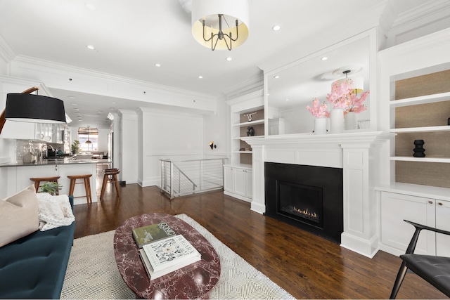 428 W 23rd St Unit 1A, New York City, NY 10011 - living room featuring a warm lit fireplace, dark wood-style floors, built in features, and ornamental molding