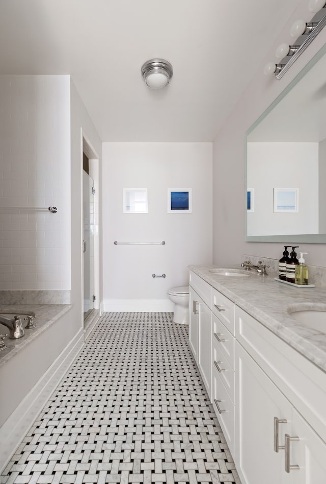 full bath with baseboards, toilet, a shower stall, double vanity, and a bath