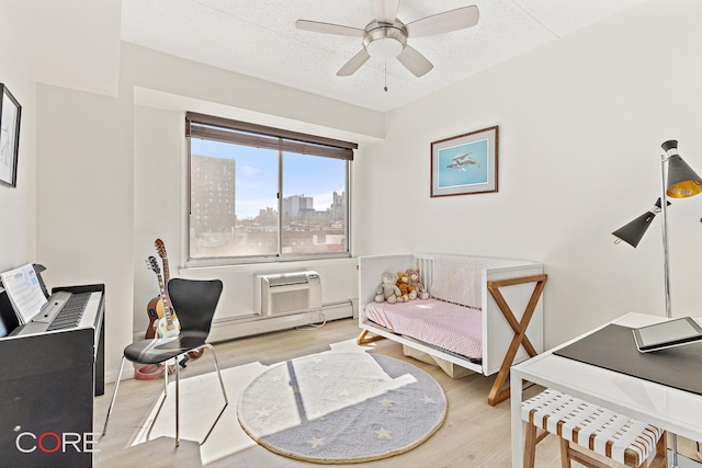 300 W 145th St Unit 6M, New York City, NY 10030 - office area featuring wood finished floors, a ceiling fan, a wall unit AC, a view of city, and a textured ceiling