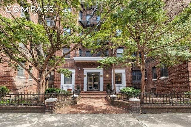 view of front of home with a fenced front yard and brick siding