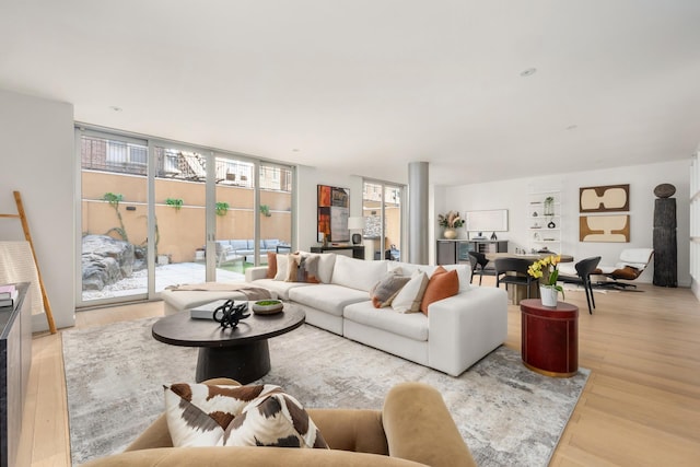 living area featuring a wall of windows and light wood finished floors