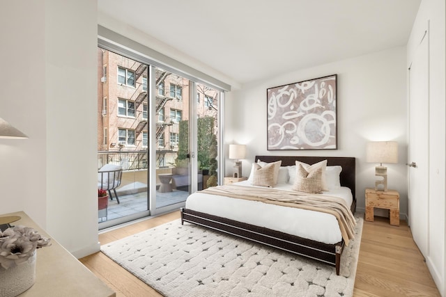 337 E 62nd St Unit Twnhse1A, New York City, NY 10065 - bedroom with access to exterior and light wood-style floors