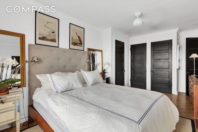 bedroom featuring wood finished floors and ornamental molding