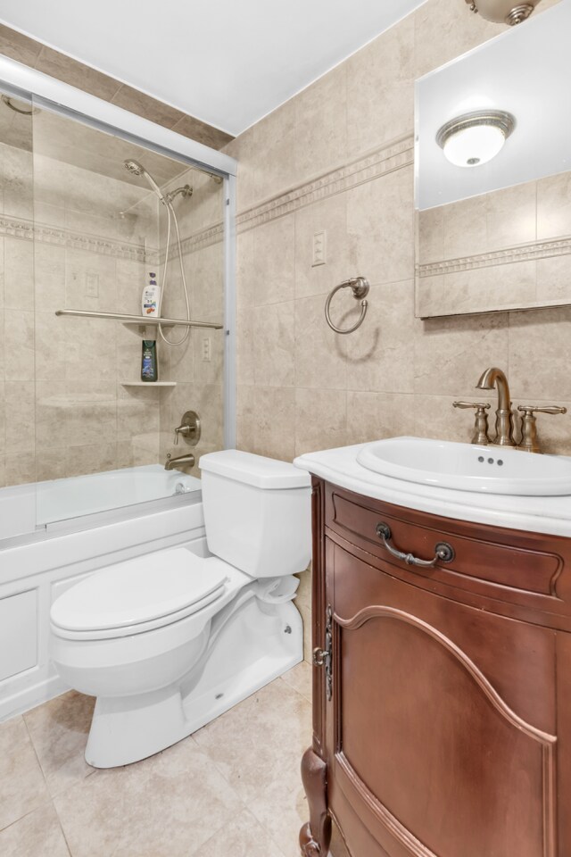 308 101st St Unit 44C, New York City, NY 11209 - full bath featuring toilet, tile walls, vanity, and bath / shower combo with glass door