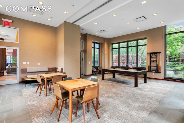 game room with stone tile flooring, pool table, a high ceiling, and recessed lighting