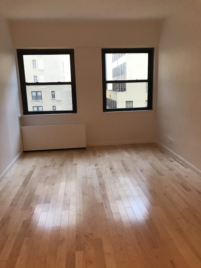 58 W 58th St Unit 9D, New York City, NY 10019 - spare room featuring wood finished floors and baseboards