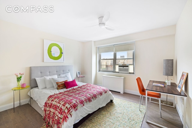 100 W 93rd St Unit 11J, New York City, NY 10025 - bedroom featuring radiator heating unit, wood finished floors, baseboards, and a desk