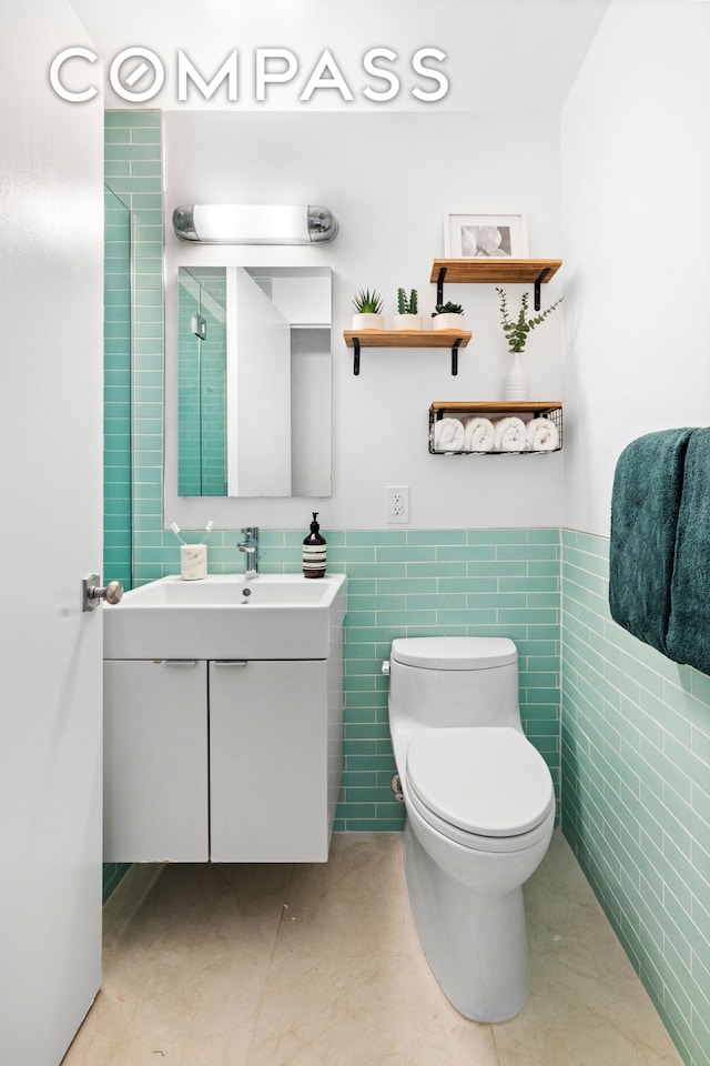 100 W 93rd St Unit 11J, New York City, NY 10025 - full bath featuring tile walls, vanity, toilet, and a wainscoted wall