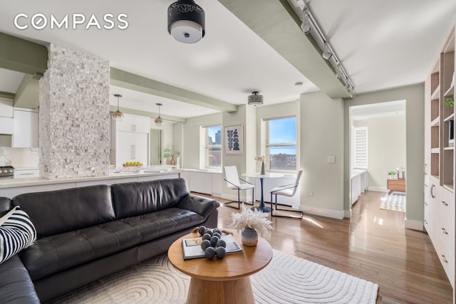 living area with light wood-type flooring and baseboards