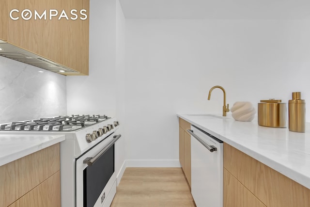 kitchen featuring a sink, light brown cabinetry, tasteful backsplash, and white appliances