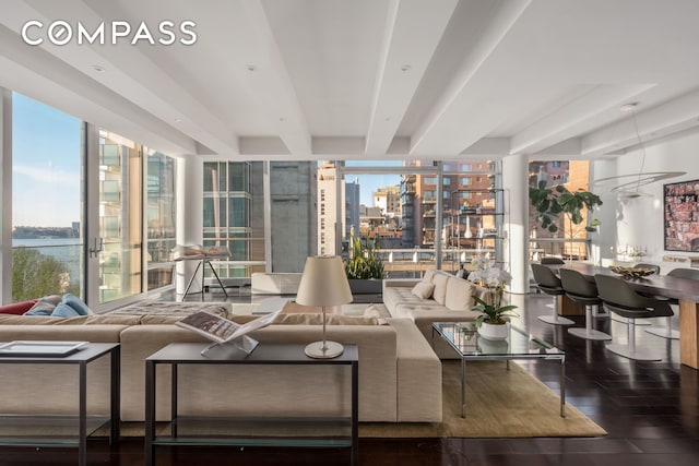 living area featuring wood finished floors, a view of city, a wall of windows, and a wealth of natural light