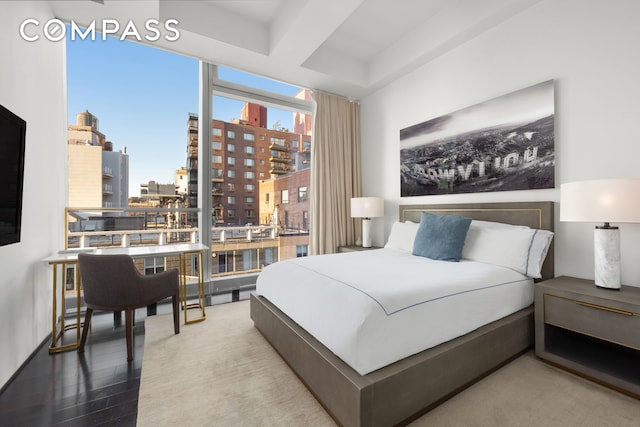 bedroom featuring a view of city and wood finished floors