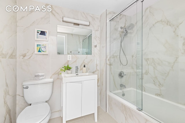 40 Schaefer St Unit 3R, New York City, NY 11207 - bathroom featuring shower / bath combination with glass door, vanity, toilet, tile patterned floors, and tile walls