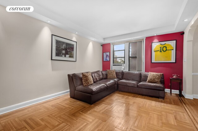 living room with baseboards, recessed lighting, a raised ceiling, cooling unit, and arched walkways