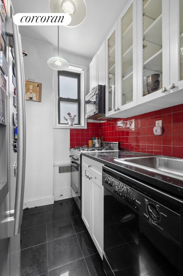 kitchen with dishwasher, range with gas stovetop, white cabinets, dark tile patterned floors, and glass insert cabinets