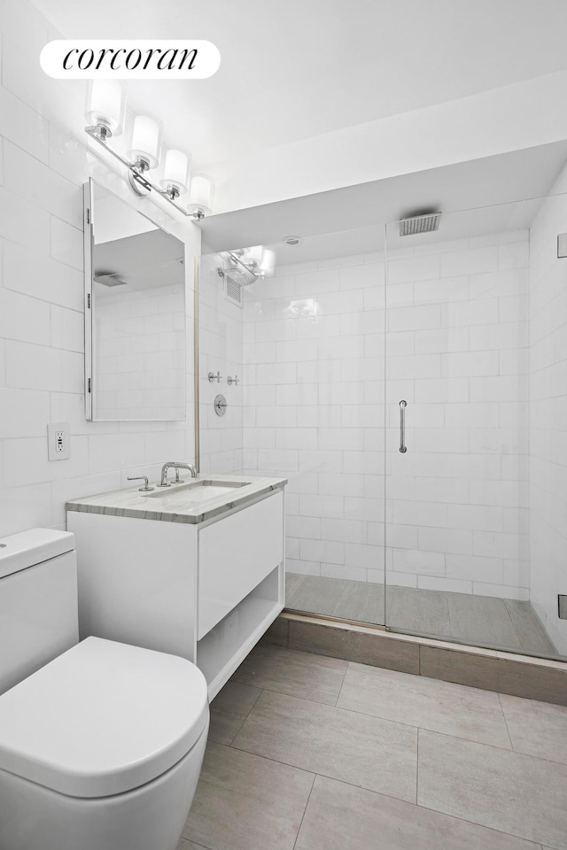 7 E 14th St Unit 1406, New York City, NY 10003 - bathroom featuring toilet, vanity, a stall shower, and tile walls