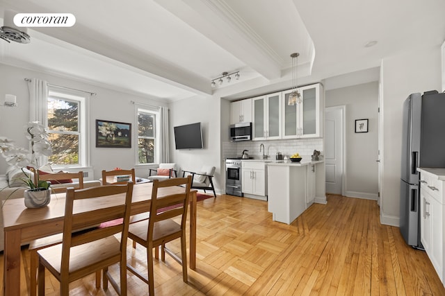 kitchen featuring glass insert cabinets, decorative backsplash, stainless steel appliances, light countertops, and white cabinets