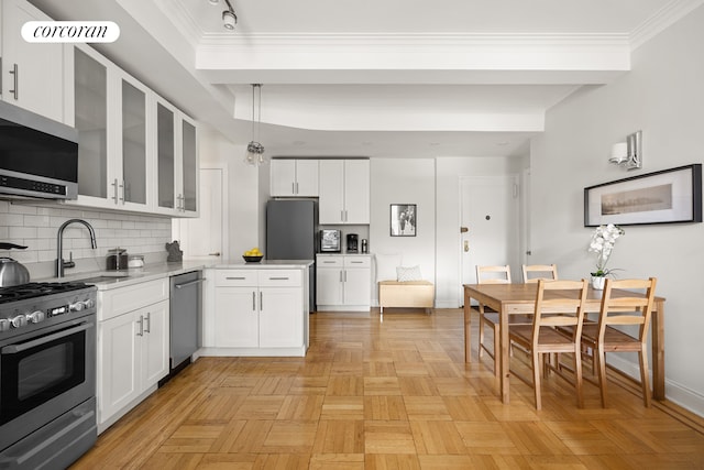 kitchen with a sink, white cabinets, appliances with stainless steel finishes, and decorative backsplash