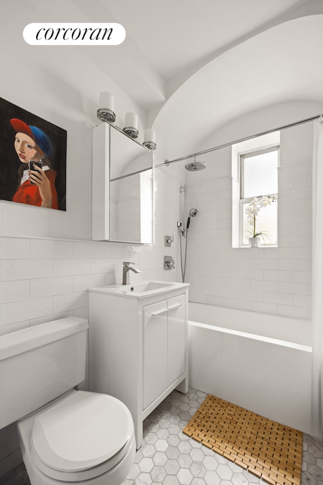 full bath with tile walls, vanity, shower / bathtub combination, toilet, and tile patterned flooring