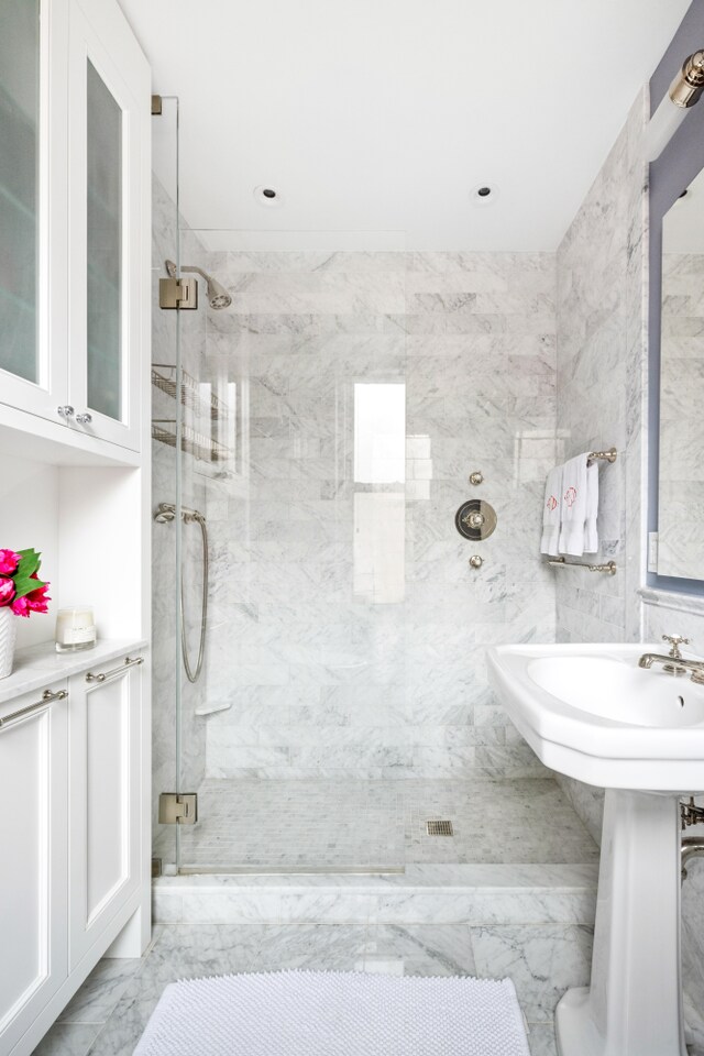 114 E 84th St Unit 8B, New York City, NY 10028 - bathroom featuring marble look tile flooring and a marble finish shower