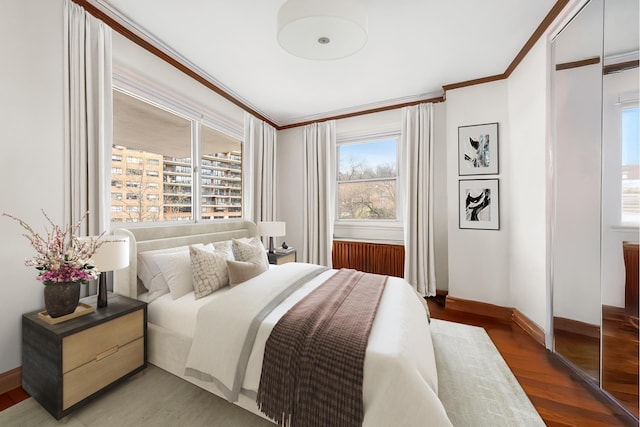 bedroom with baseboards, ornamental molding, and light wood-style floors