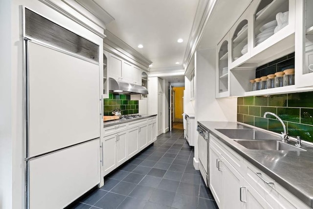 kitchen featuring dark tile patterned flooring, ornamental molding, white cabinets, under cabinet range hood, and white built in fridge