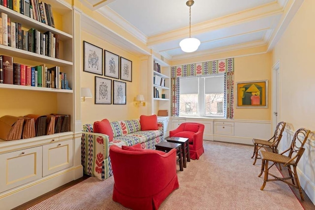 living area with carpet flooring, built in features, ornamental molding, and a wainscoted wall