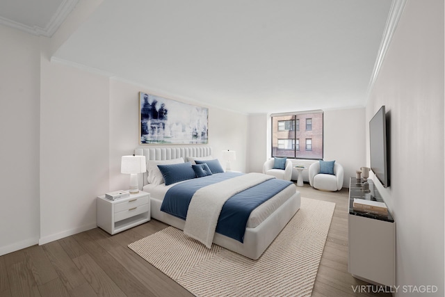 bedroom featuring baseboards, ornamental molding, and wood finished floors