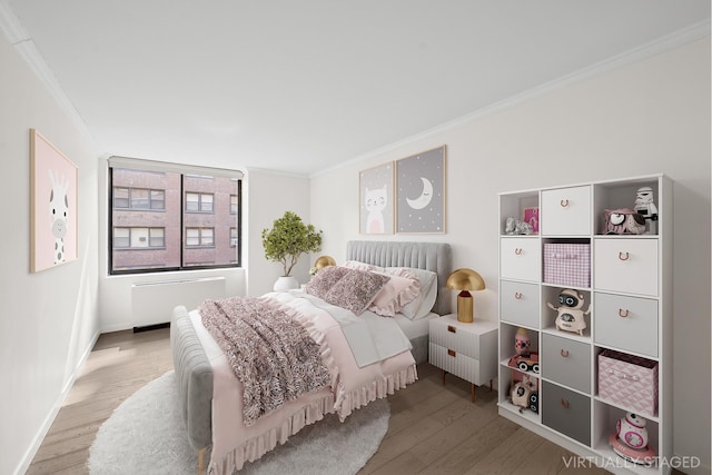 bedroom with baseboards, ornamental molding, wood finished floors, and radiator