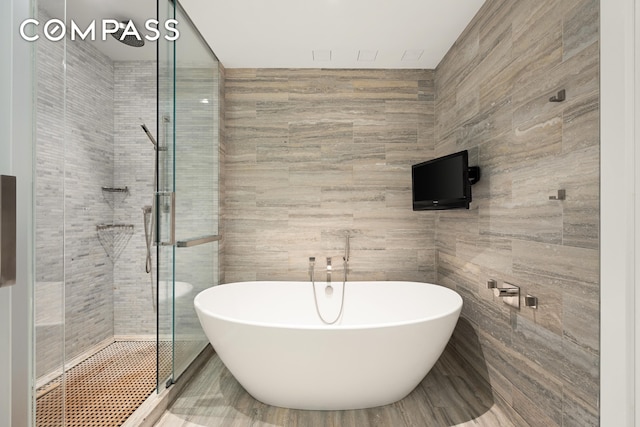 400 W 12th St Unit 4J, New York City, NY 10014 - full bath featuring a freestanding bath, tile walls, and a shower stall