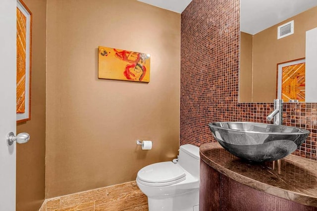 half bathroom with visible vents, toilet, and vanity